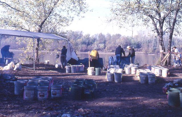 Grouped buckets, a canopy, and six people working