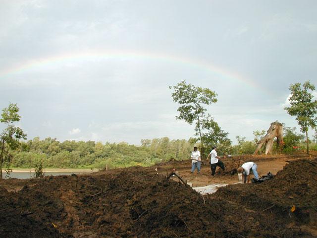 Three people Shovel scraping to remove the lower portion of the historic plowzone and expose the intact subsoil and any cultural features that intrude the subsoil