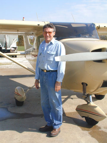 Frank Parrish standing by an airplane