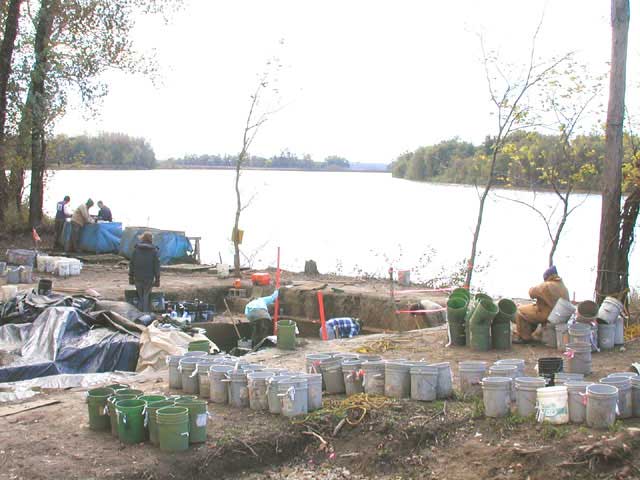 Eight people working various areas of the site with river in background