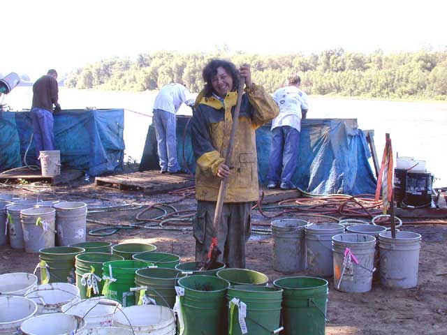 Person stirring the water-soaked excavated soil to dissolve the clods