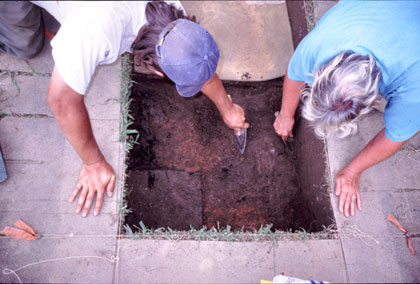 Cheryl Munson and Jon Criss carefully exposing the subterranean floor of the burned house