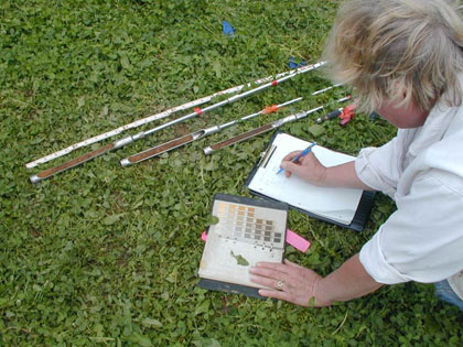 Cheryl Munson logging in soil colors and textures, plus small artifacts, observed in cores extracted from a possible burned house feature.