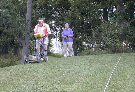 Dr. Nelson Shaffer operating a GPR system with Cheryl Munson recording the location of the pass