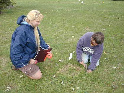 USI student Theresa Oser and Project Research Assistant Jocelyn Turner capping grid nails to protect them and make them easy to find when geophysical surveys and soil core work resumes next year.