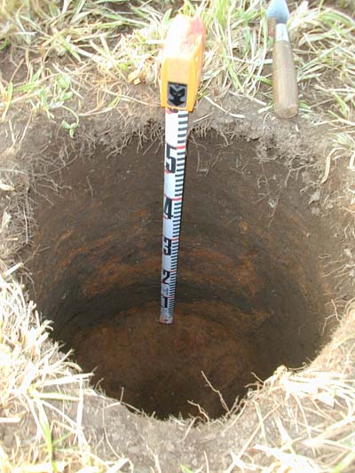 The sample at N940, E960 revealed a feature on one side of the hole that had been filled with lenses of daub